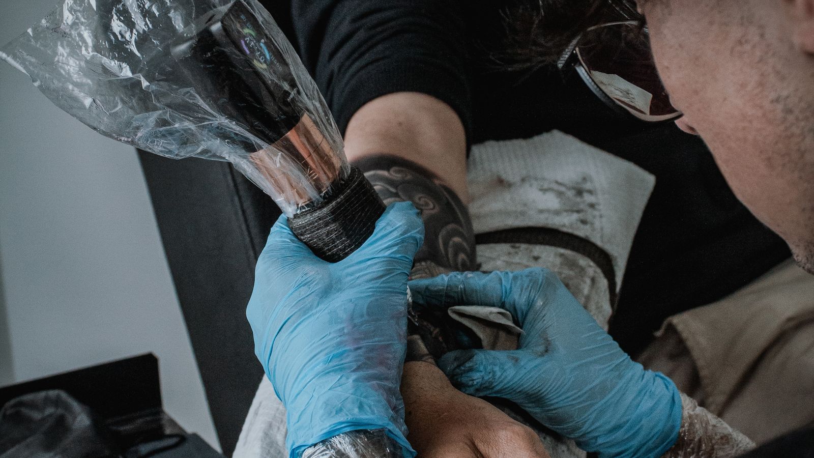 Tatuatore mentre realizza un disegno complesso