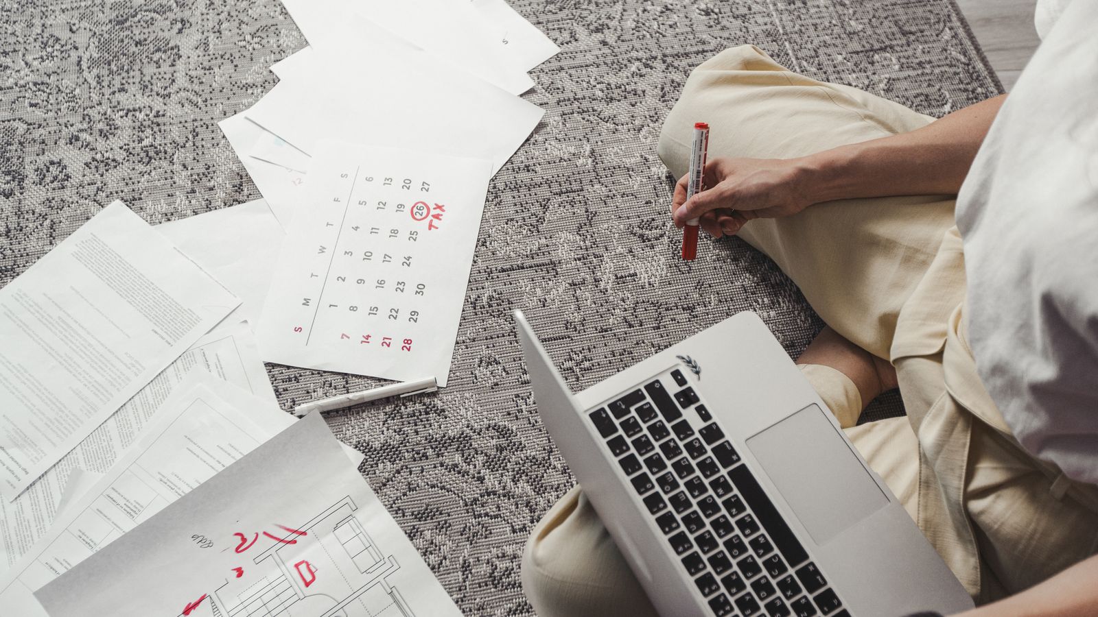 Persona al lavoro su un portatile circondata da documenti