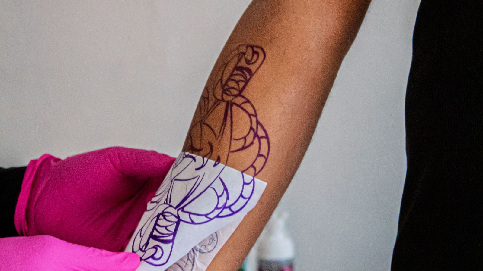 Applicazione dello stencil sul braccio di un cliente